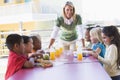 Kindergarten teacher supervising children Royalty Free Stock Photo