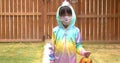 A kindergartener wearing a facemask holding a pumpkin jack-o-lantern during halloween during a pandemic. Concept covid 19 during