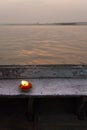 Kindle lit on edge of wooden boat at sunset on Ganges river in Varanasi, India Royalty Free Stock Photo