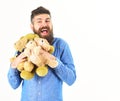 Kindness, care and tenderness concept. Guy with beard hugs toys