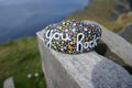 Kindness rock with painted you rock message and colorful polka dots on stone wall Royalty Free Stock Photo