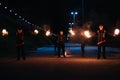 KINESHMA, RUSSIA - OCTOBER 09, 2021: Fire show with men and women with burning torches at a pyrotechnic performance