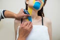 Kinesio taping. The physiotherapist applies kinesiology tape to the patient`s neck. Post-traumatic rehabilitation Royalty Free Stock Photo