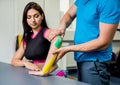 Kinesiotaping. Physical therapist applying tape to young beautiful woman Royalty Free Stock Photo