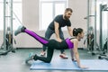 Kinesis technology, kinesitherapy, healthy lifestyle. Young woman doing rehabilitation exercises with personal instructor using Royalty Free Stock Photo