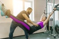 Kinesis technology, kinesitherapy, healthy lifestyle. Young woman doing rehabilitation exercises with personal instructor using