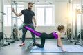 Kinesis technology, kinesitherapy, healthy lifestyle. Young woman doing rehabilitation exercises with personal instructor using