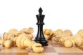 King among fallen chess pieces on wooden board against white background Royalty Free Stock Photo