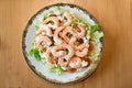 King prawn salad with lettuce and tomato. On a white plate with a gold trim, placed on a wooden table. Seen from above Royalty Free Stock Photo