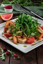 King prawn salad with tomatoes, arugula and grapefruit on a wooden table in a restaurant close-up Royalty Free Stock Photo