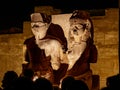 King Tutankhamun and his Queen at the Luxor Temple in Egypt surrounded by tourists visiting the Luxor Temple at night