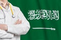 Kingdom of Saudi Arabia healthcare concept with doctor on flag background. Medical insurance, work or study in the country