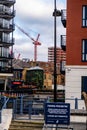 Distant Construction Site And Tower Crane Working Behind A Town Centre Residential Apartment Buildings