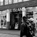 Two People Or Shoppers Walking Past A River Island Fashion Retail Shop Front