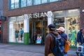 People Or Shoppers Walking Past A High Street Branch Of Fashion Retailer River Island Royalty Free Stock Photo