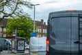 Two Works Vans Or Delivery Transport Waiting In Traffic By A Bus Stop In A Town Centre