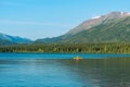 A fisherman in an orange boat on the lake at Kiniskan Lake Provincial Park, British Columbia, Canada