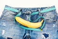 Kinky banana fruit on jeans crotch, close up.