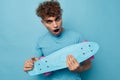 kinky guy skateboard in hand in blue t-shirts isolated background Royalty Free Stock Photo