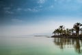 Kinneret, Galilee sea, Israel, Tiberias lake with palms on the seashore calm green water and blue sky. Biblical Place where Jesus