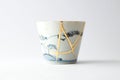 Antique blue and white cup restored with antique kintsugi real gold technique Royalty Free Stock Photo