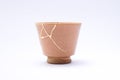 Broken Japanese handmade cup restored with the antique japanese kintsugi real gold technique Royalty Free Stock Photo