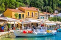 KIONI PORT, ITHACA ISLAND - SEP 19, 2014: fishing boat on turquoise sea water in Kioni port with colourful houses. Greece is very