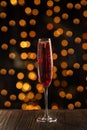 Kir Royal Champagne Cocktail on wood background, copy space. Flute glass with berry sparkling champagne drink for