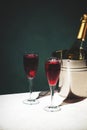 Kir Royale alcoholic cocktail with blackcurrant liqueur, prosecco and cocktail cherry. Dark green background, hard light and Royalty Free Stock Photo