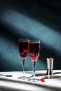 Kir Royale cocktail with black currant liqueur, prosecco wine and red cocktail cherry. Dark green background, hard light and Royalty Free Stock Photo