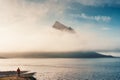 Kirkjufell mountain hidden in foggy over atlantic ocean and male tourist standing in summer at Iceland Royalty Free Stock Photo