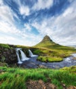 Kirkjufell. Mountains and waterfall in the Iceland. Natural landscape in the summer. Grass and river. Famous place.