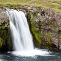 Kirkjufellsfoss waterfall near the Kirkjufell mountain, woman en