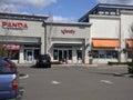 Kirkland, WA USA - circa April 2021: View of a woman seated on a bench outside of an Xfinity store in Totem Lake