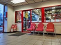 View of the waiting area inside a Discount Tire shop with a window into the maintenance area