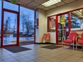 View of the waiting area inside a Discount Tire shop with a window into the maintenance area