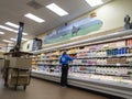 Kirkland, WA USA - circa March 2022: Angled view of an adult woman worker inside a Trader Joe`s grocery store, restocking the