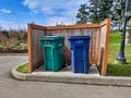 Street view of trash and recycling cans at a park near Lake Washington on a sunny day