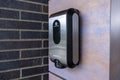 Kirkland, WA USA - circa May 2021: View of a black plastic hand sanitizer dispenser attached to a red brick wall on the outside of