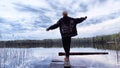 Kirov, Russia - April 29, 2023: Girl or woman walks along old wooden pier, with lake in background during evening and