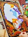 KIROV, RUSSIA - AUGUST 6, 2017: Adult woman drawing colorful bouquet on the canvas in the local art studio