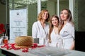 Kirov, Russia - February 25, 2019: Three nice young women in white bathrobes standing near reception in spa. Female customers Royalty Free Stock Photo