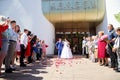 Kirov, RUSSIA - June 20, 2020: The newlyweds near the registry office and people, guests, relatives rejoice and throw Royalty Free Stock Photo