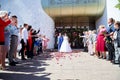 Kirov, RUSSIA - June 20, 2020: The newlyweds near the registry office and people, guests, relatives rejoice and throw Royalty Free Stock Photo