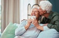 Kiss, coffee and senior couple laughing, talking and smile during retirement in the living room of their house. Relax Royalty Free Stock Photo