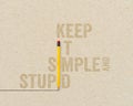 KISS Concept - Keep it simple and stupid with yellow pencils on brown paper and chalkboard background Royalty Free Stock Photo