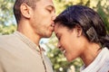 Kiss, forehead and couple in a park to relax, peace and calm together in nature. Young, happy and man with love and care Royalty Free Stock Photo