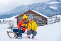 Kiss. Funny boy and girl having fun with a sleigh in winter. Cute children playing in a snow. Winter activities for kids Royalty Free Stock Photo