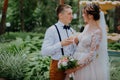 bride and groom with glasses of champagne in the park celebrate their wedding day. A loving couple of newlyweds drinks Royalty Free Stock Photo