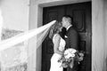 The kiss. Groom kisses bride on forehead in front of church portal. Royalty Free Stock Photo